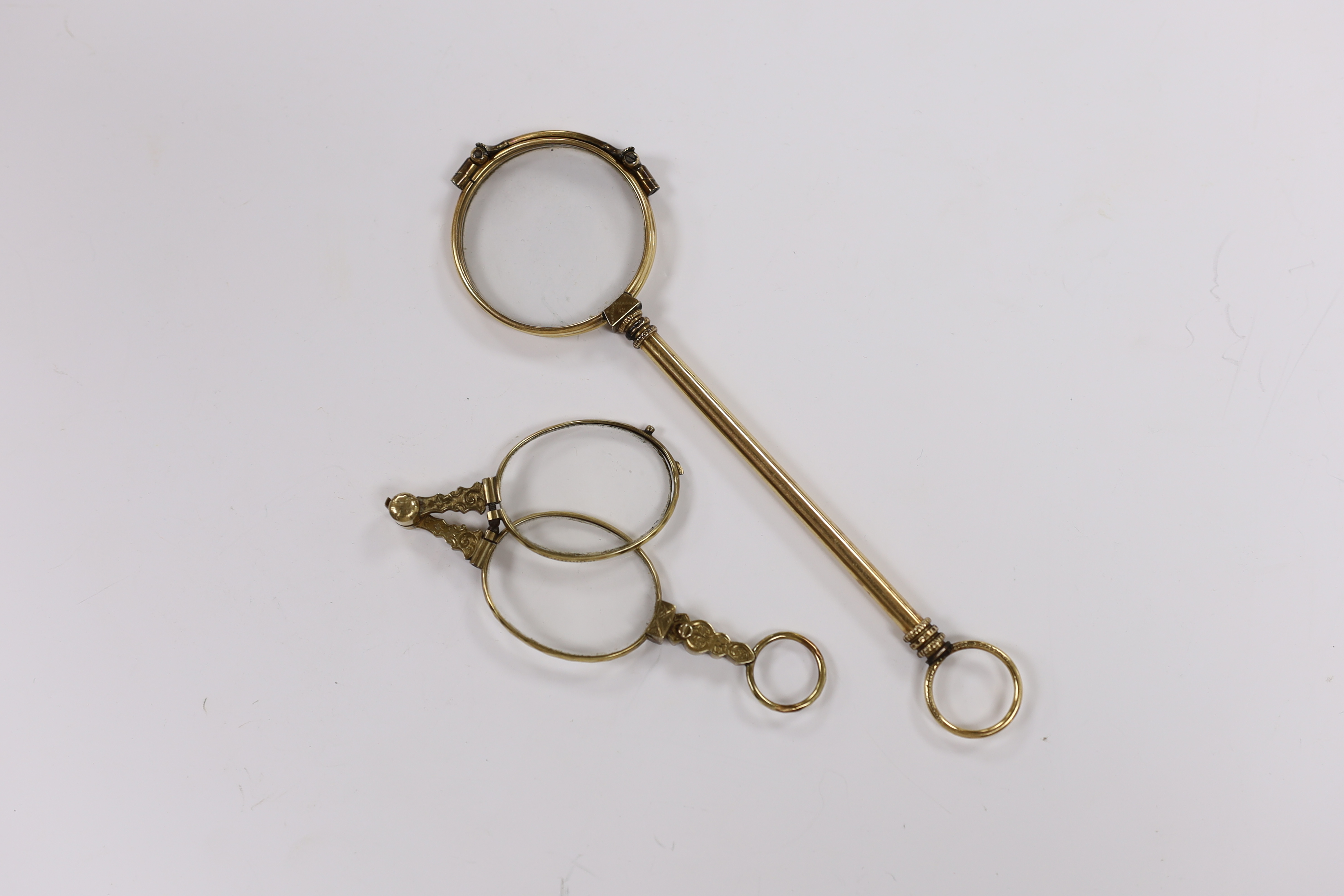 A pair of early 20th century engraved yellow metal overlaid lorgnettes, 89mm and one other large pair of lorgnettes.